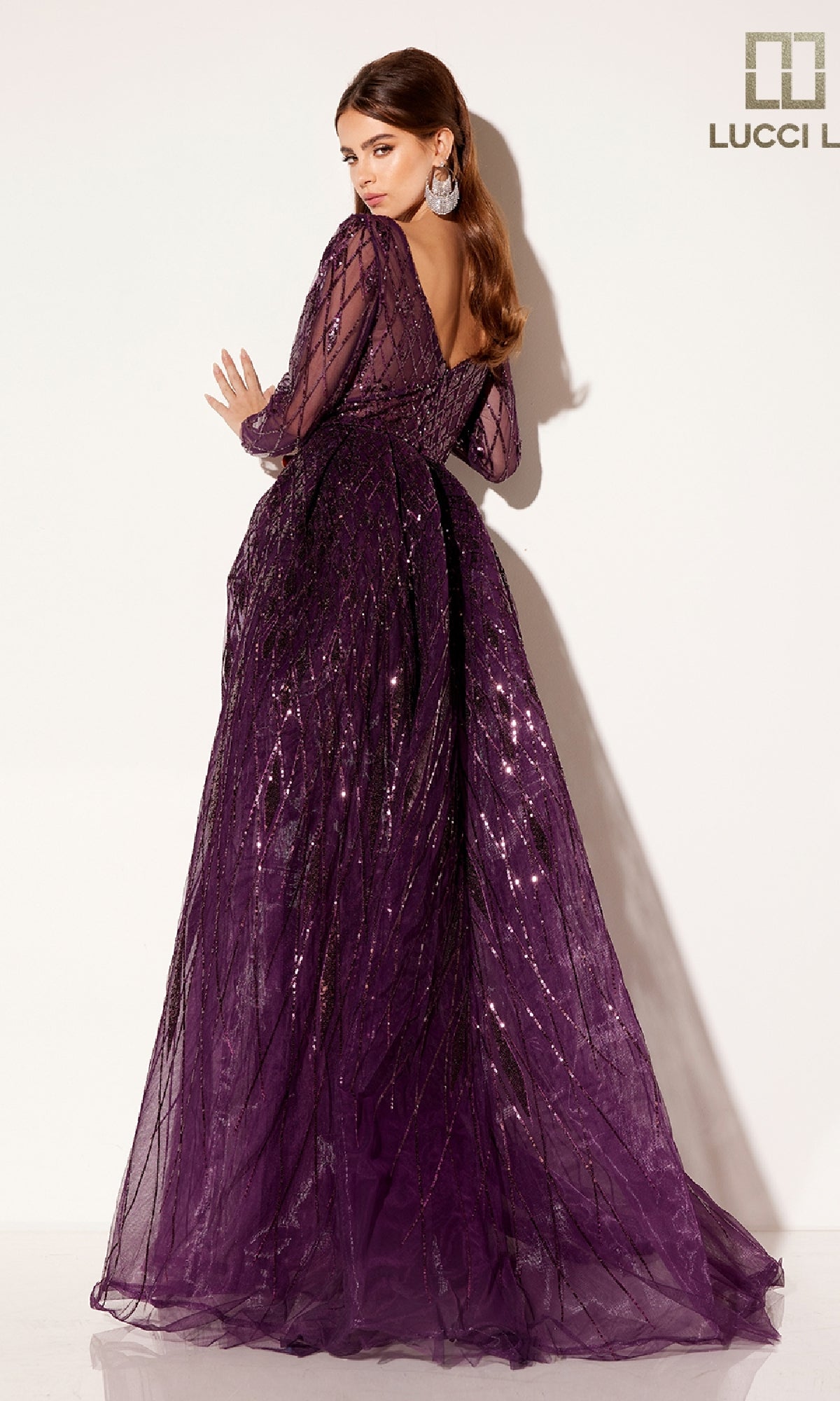 A woman models the Lucci Lu C8095 long formal dress—floor-length, long-sleeve, deep purple sequins with a low back—posing against a plain light background.
